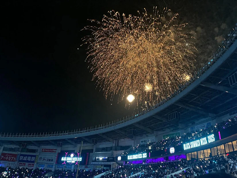 スタジアムの観客席の後ろに花火が上がっている。