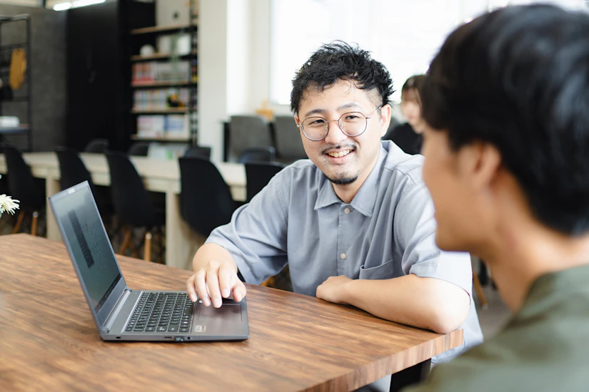 2人のノベルティメンバーが笑顔で話し会う様子