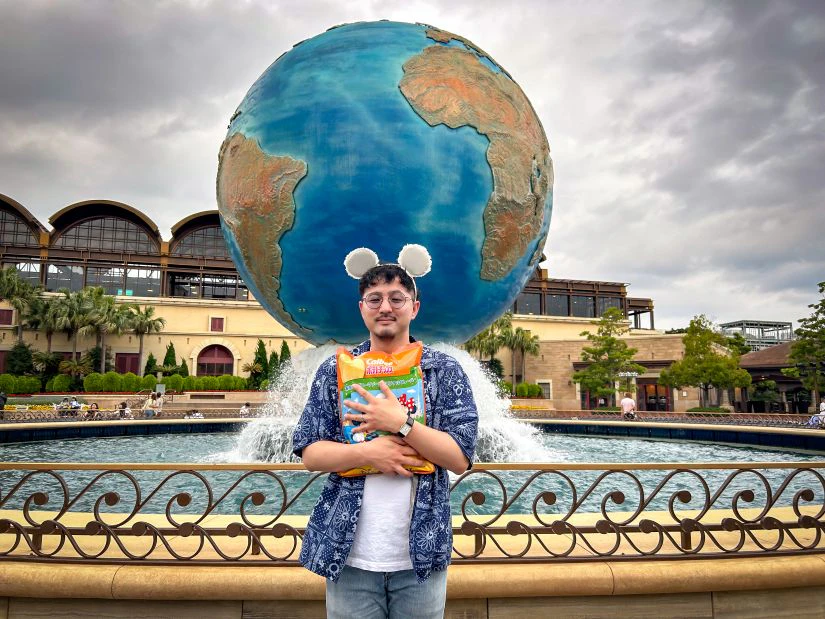 会社から支給された軍資金で買い物を楽しむ男性メンバー。お土産のポテトチップスの袋を抱きかかえるように持っている。