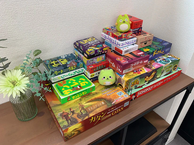 ボードゲームが20個ほど棚の上に山積みになっている。