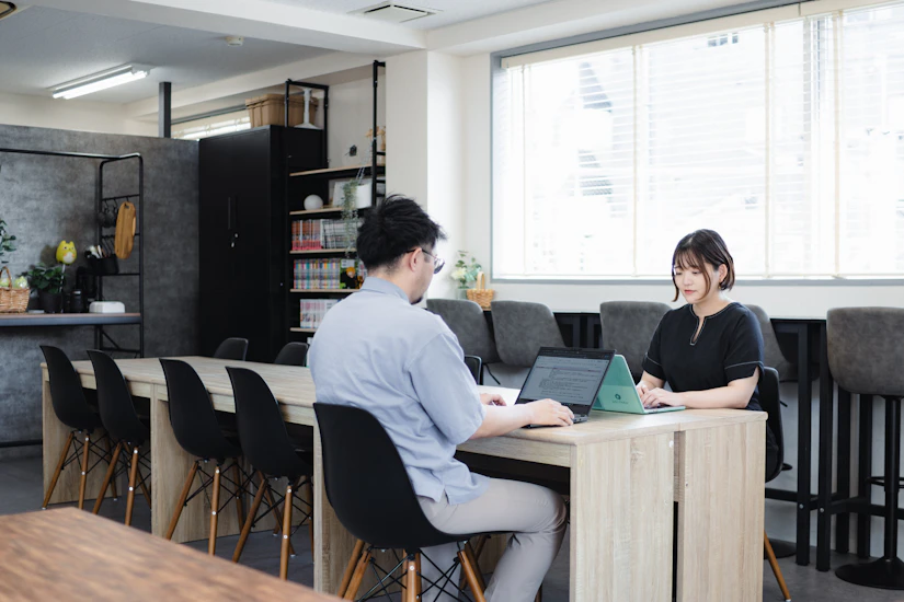 オフィスでPCに向かって仕事をするノベルティ社員2名。