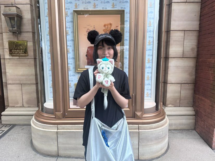 会社から支給された軍資金で買い物を楽しむ女性メンバー。ディズニーキャラクターのジェラトーニのぬいぐるみを手にしている。