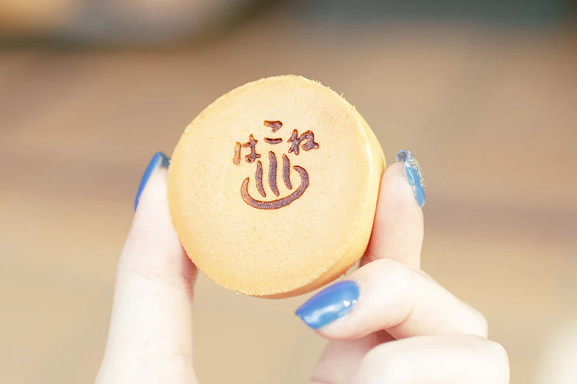 菊川商店の箱根まんじゅうを手に持っている写真