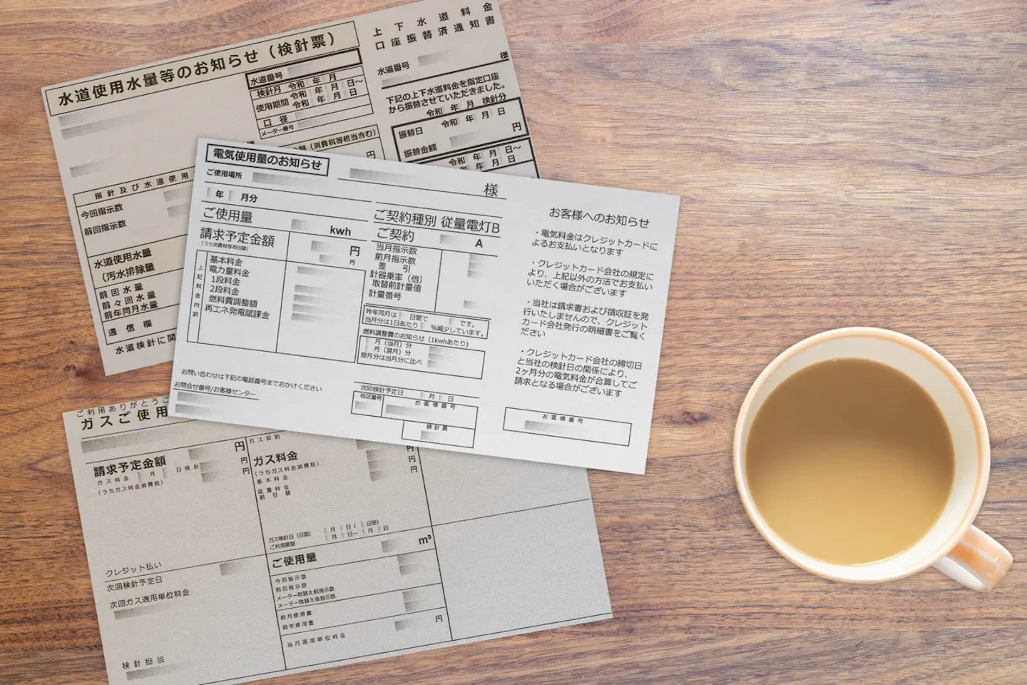 光熱費の請求書とコーヒーカップ（電気代・ガス代・水道代）