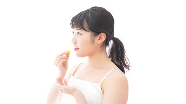 薬を飲む女性