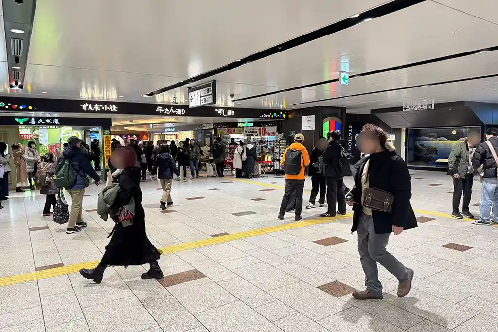 Gyutan Street entrance on the third floor at Sendai Station near the Shinkansen area, with shops and passing travelers.