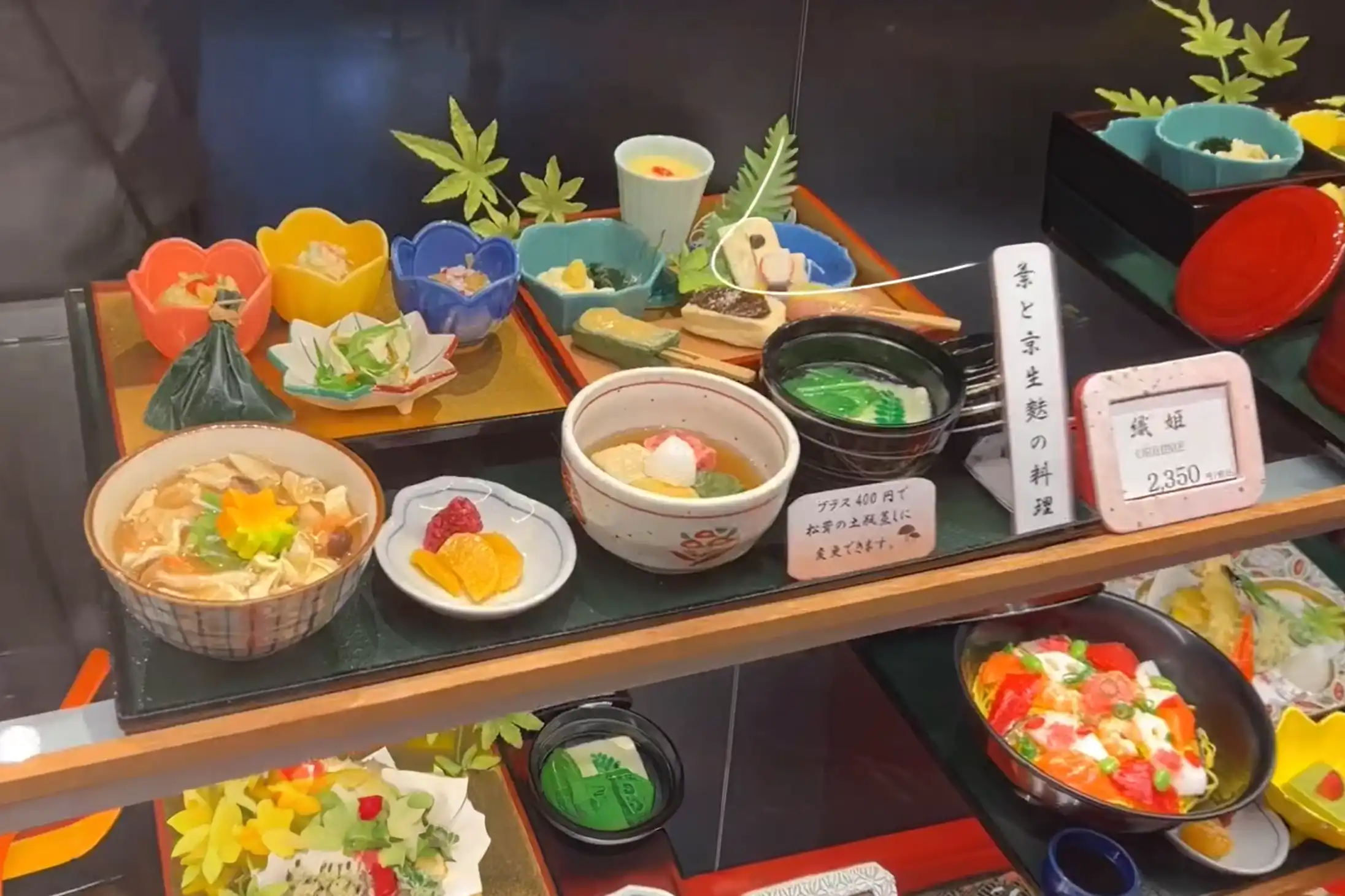 Kyoto-style cuisine sets displayed in a restaurant case at Kyoto Station, featuring several traditional dishes