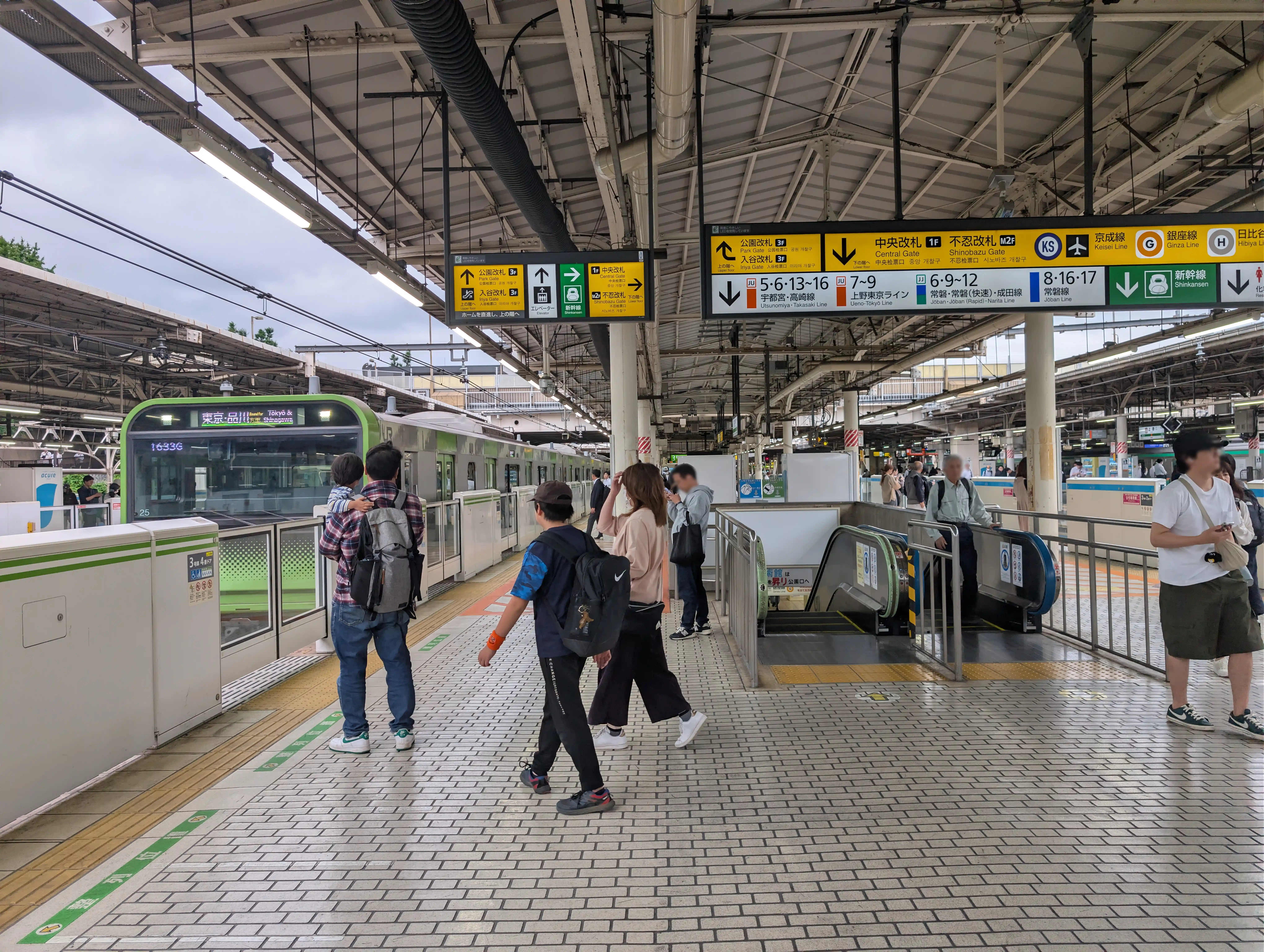 JR Ueno Station local line platform with travelers and signs for Shinkansen transfer