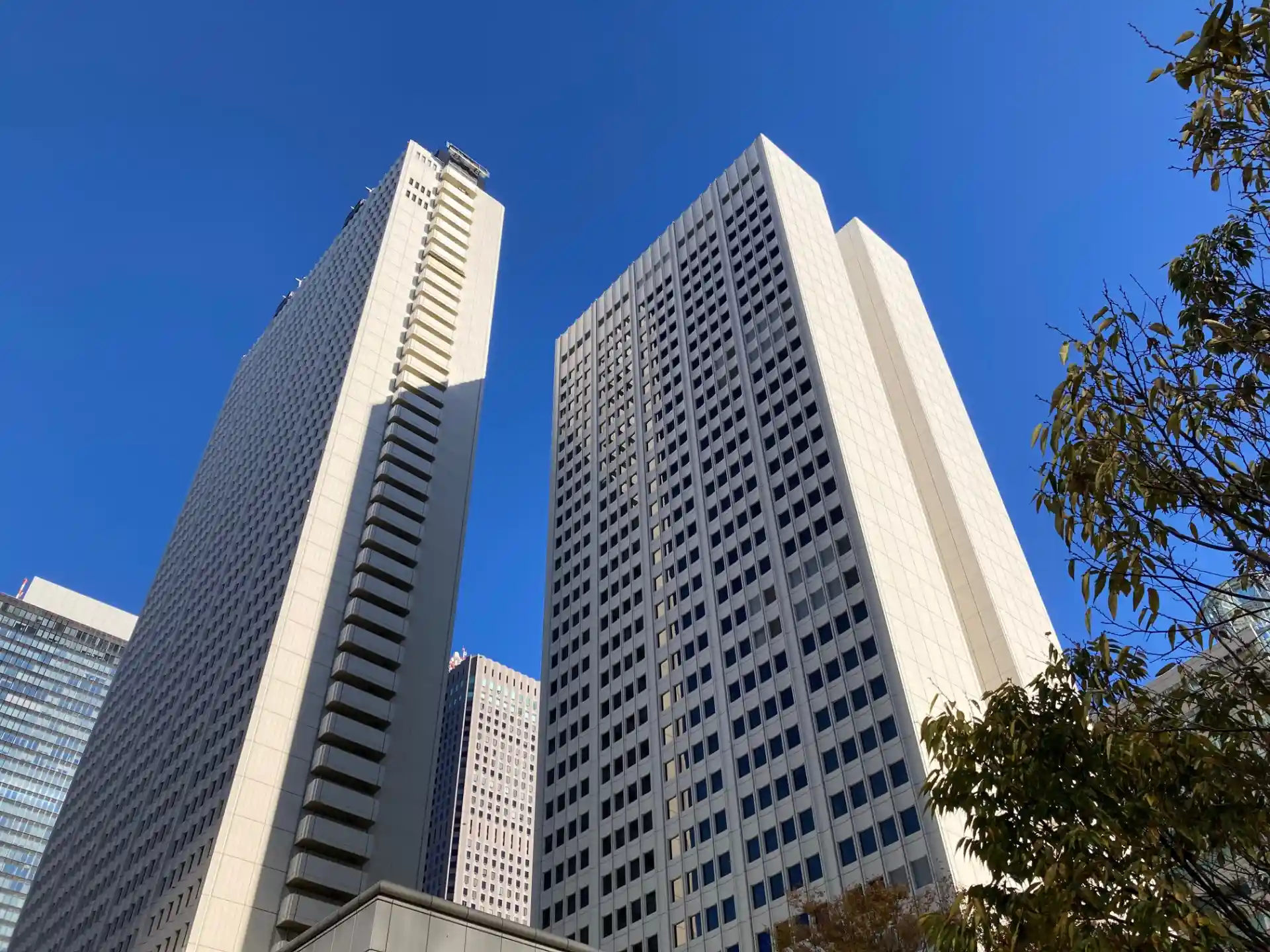 High-rise hotel buildings in Shinjuku with modern white towers and clear blue sky