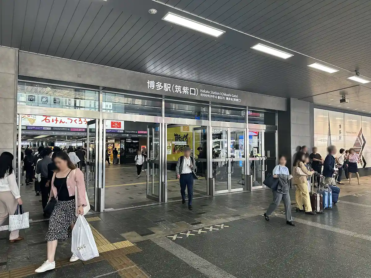 Chikushi Exit entrance at Hakata Station with travelers entering and leaving the station building