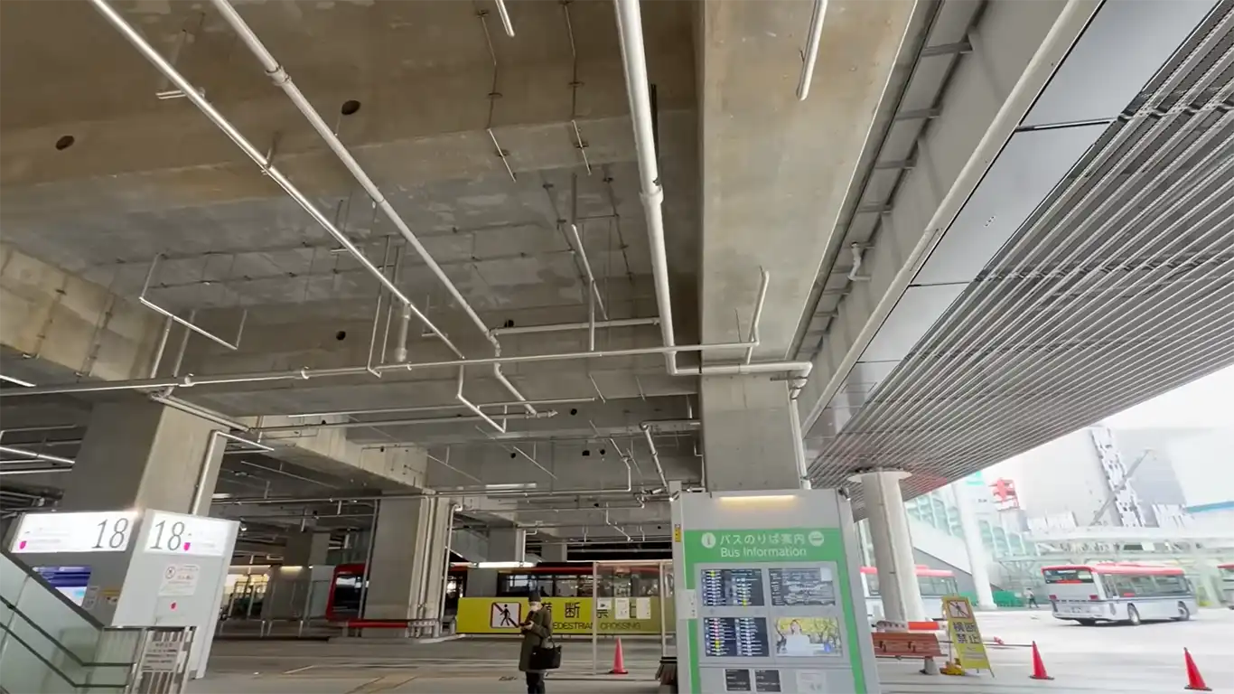 Bus terminal area under the elevated tracks at Niigata Station, where travelers board local and regional buses