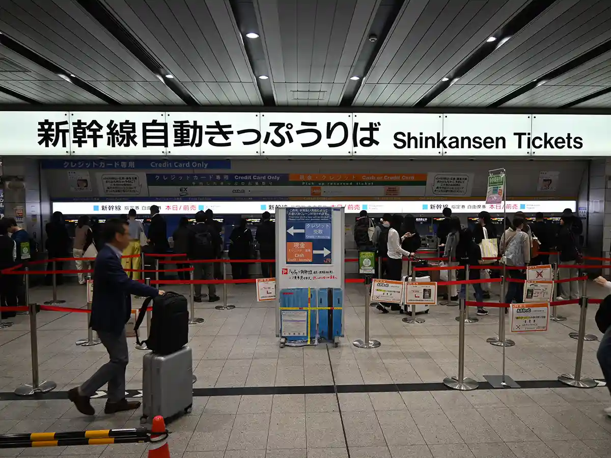 Shinkansen ticket machines at Shin-Osaka Station Central Gate with travelers preparing for boarding