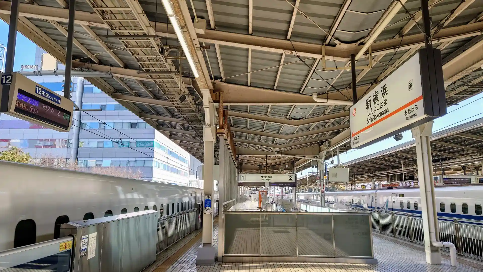 Shinkansen platforms at Shin-Yokohama Station with trains and signs for the Tokyo direction