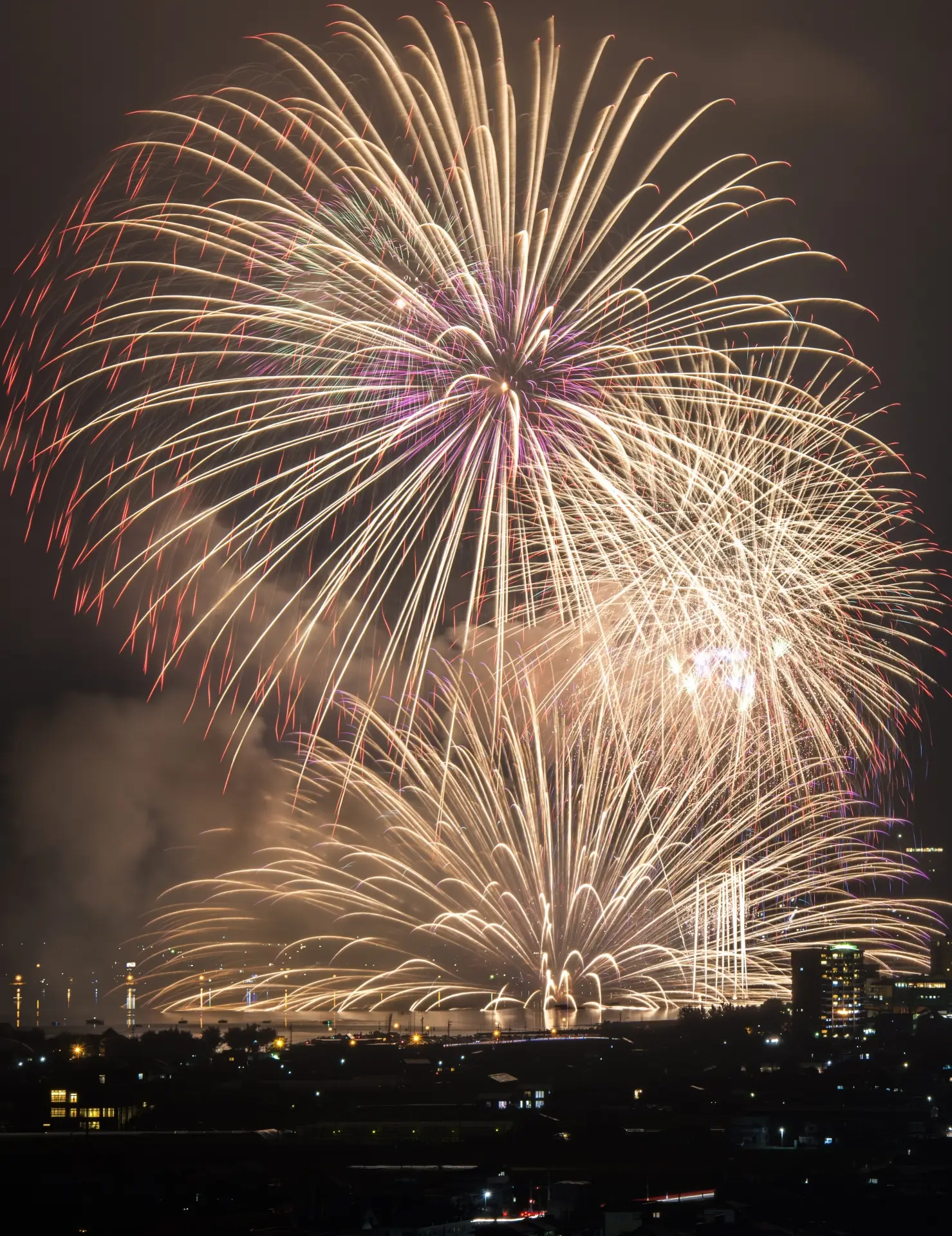 Brilliant fireworks lighting up the night sky and reflecting on Lake Suwa at Japan’s scenic summer festival