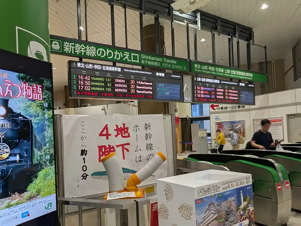 Close view of the Shinkansen Transfer Gate at JR Ueno Station with signs and departure boards