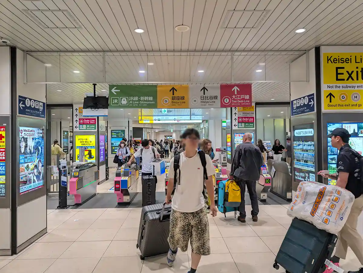 Keisei Ueno Station ticket gate with signs for JR Line, Shinkansen, and subway transfers