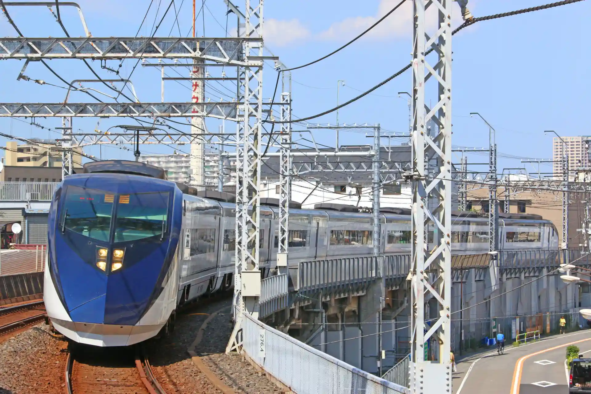 Keisei Skyliner express train on curved railway tracks with city buildings in the background