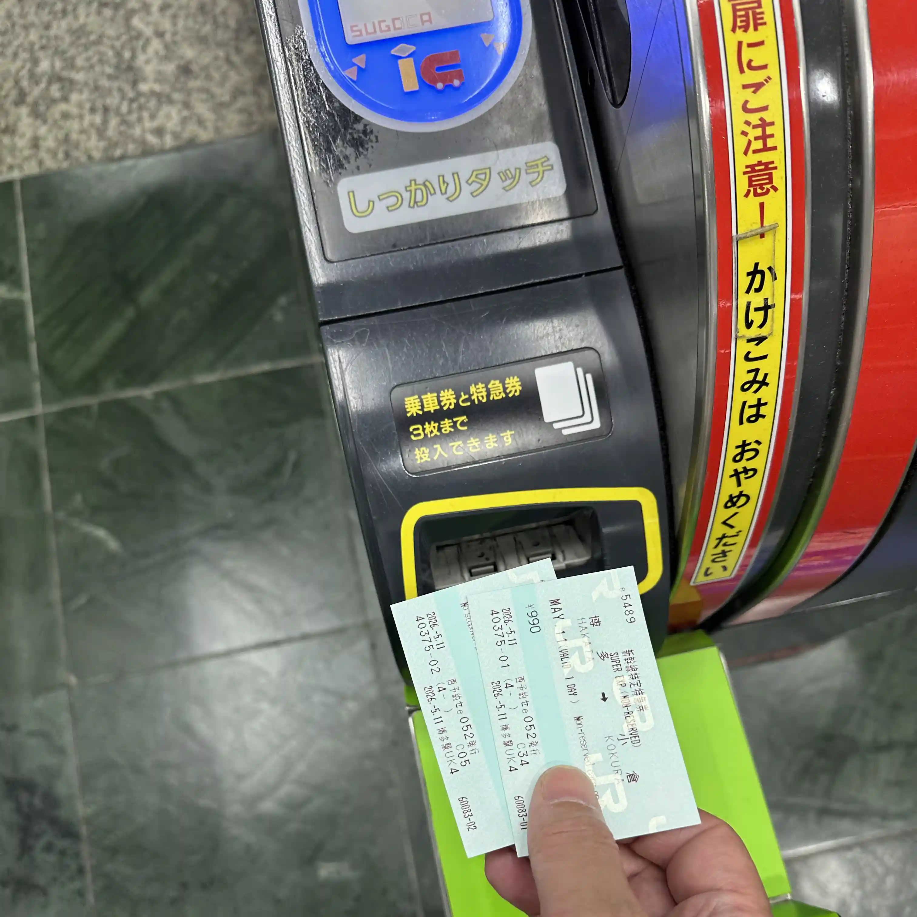 Passenger inserting Shinkansen tickets into the automatic ticket gate at Hakata Station