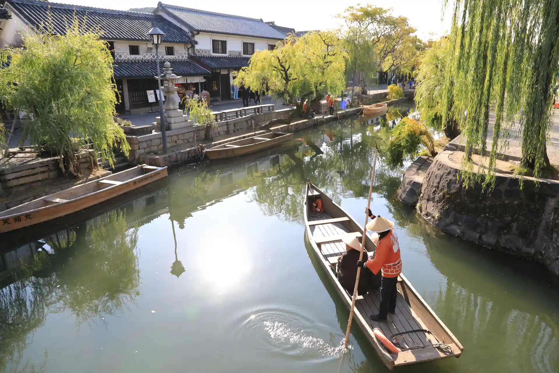 Boat ride on the historic canal in Kurashiki Bikan district, showing preserved townhouses and waterway