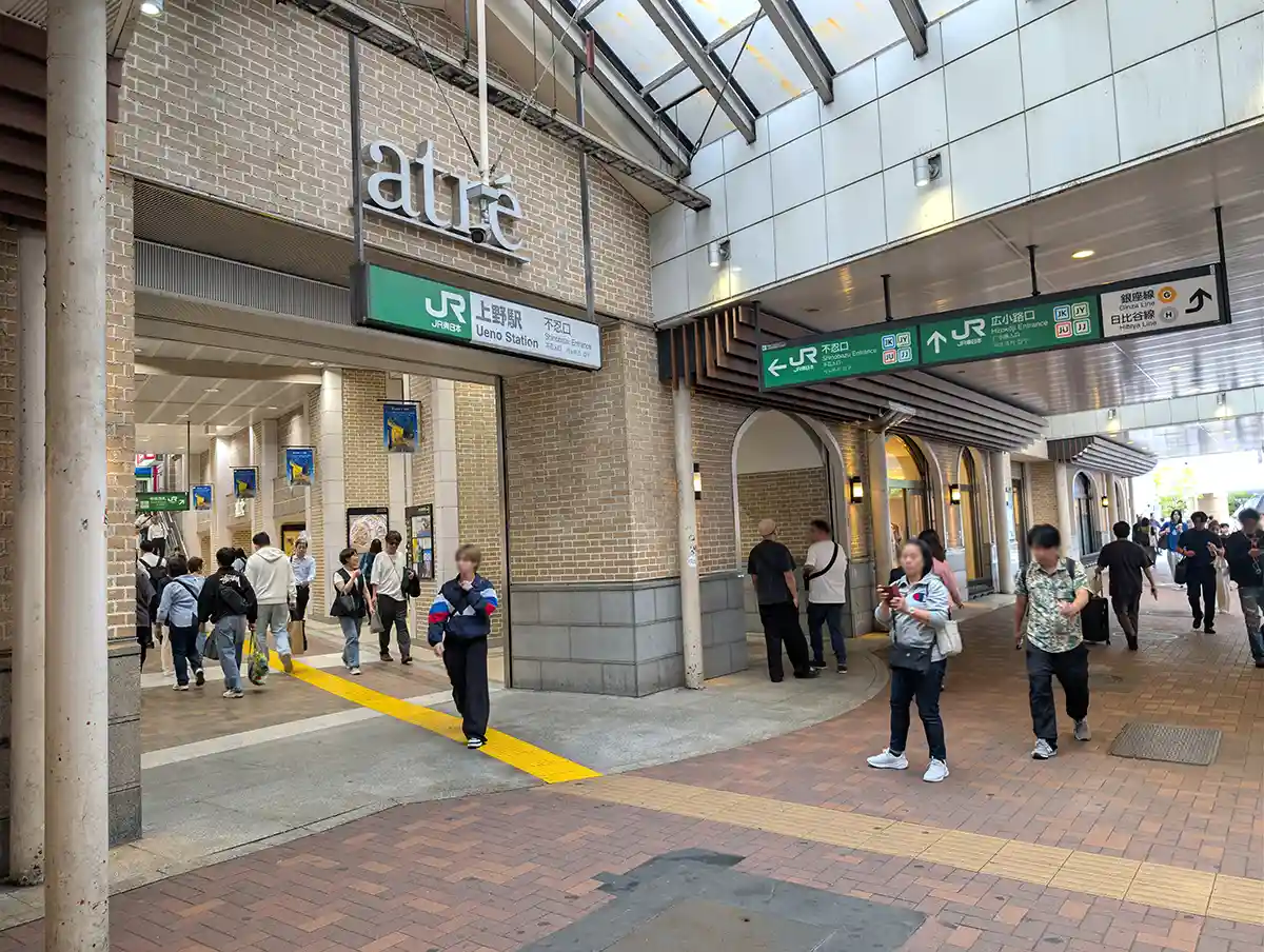 Ueno Station Shinobazu Exit beside Atre Ueno with entrance signs and people walking