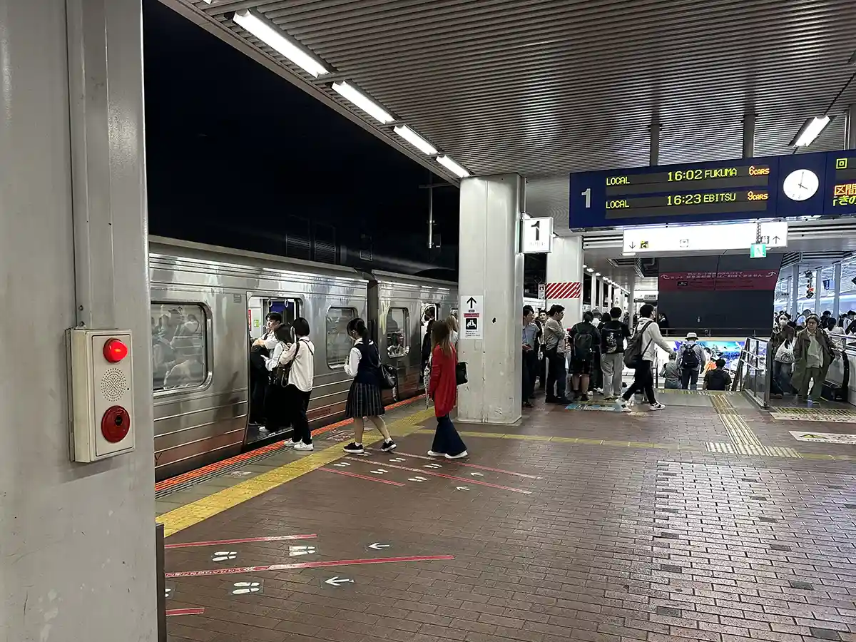 JR conventional line platform at Hakata Station with passengers boarding and getting off a local train