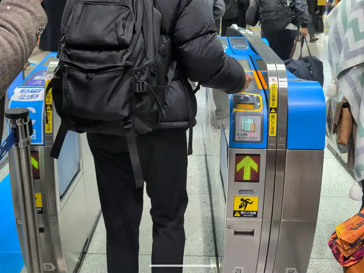 Close-up of passenger using ticket gate at Shinagawa Station south transfer area