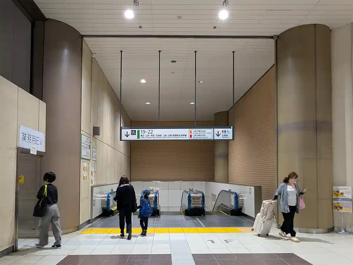 Escalators inside JR Ueno Station Shinkansen gate area leading down from 1F to platforms 19 to 22