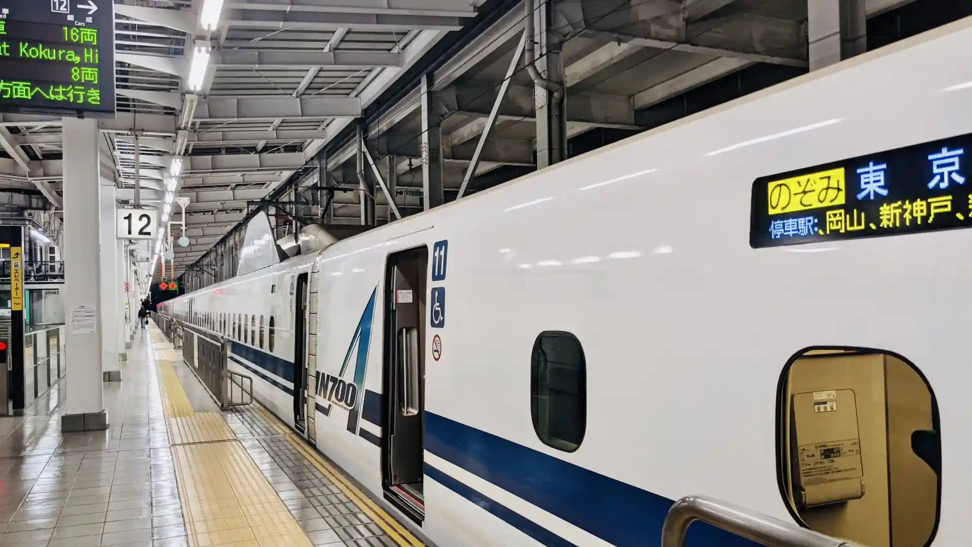 Nozomi Shinkansen train on the platform showing its service name and Tokyo destination