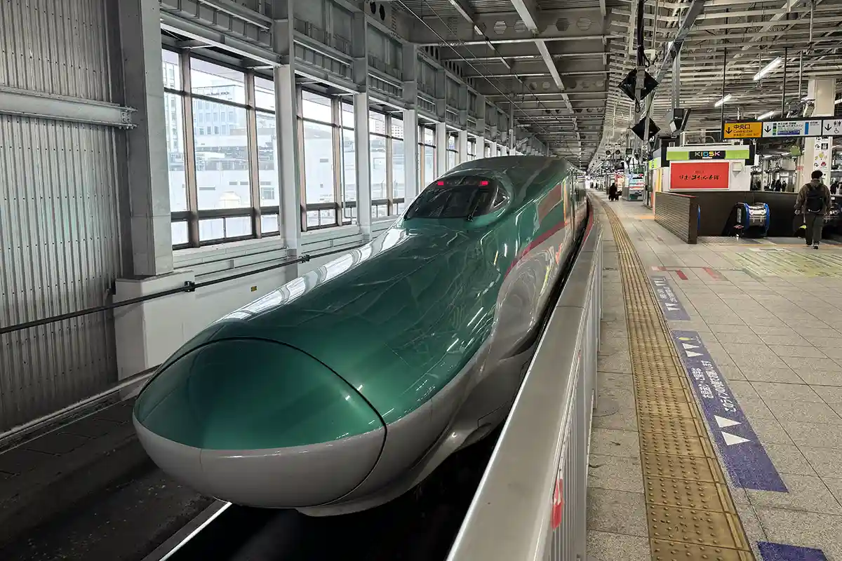 Tohoku Shinkansen train stopped at Sendai Station platform, showing the train used for travel to Tokyo and northern Japan.