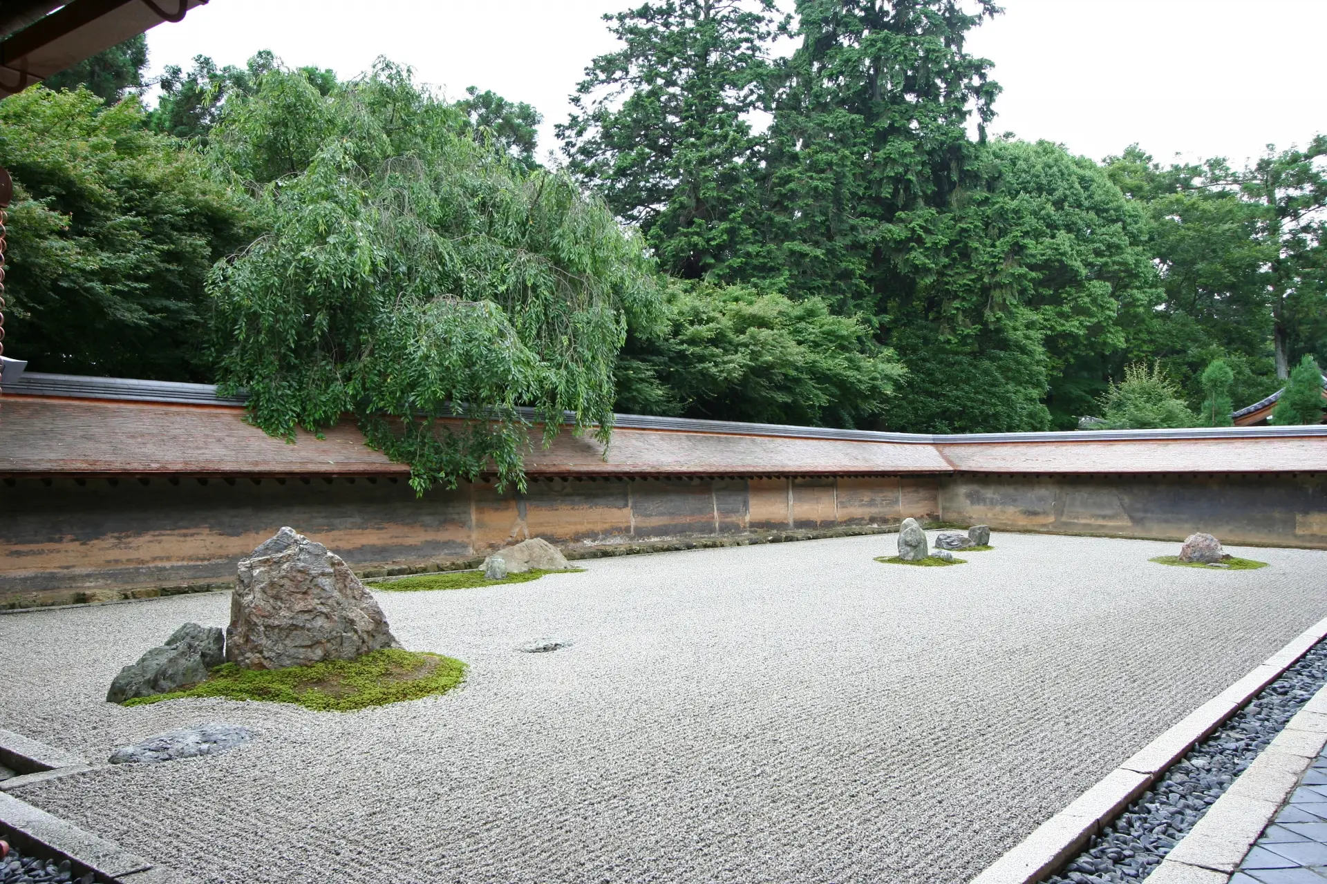 Famous Kyoto rock garden at Ryoan-ji Temple with carefully placed stones and raked gravel