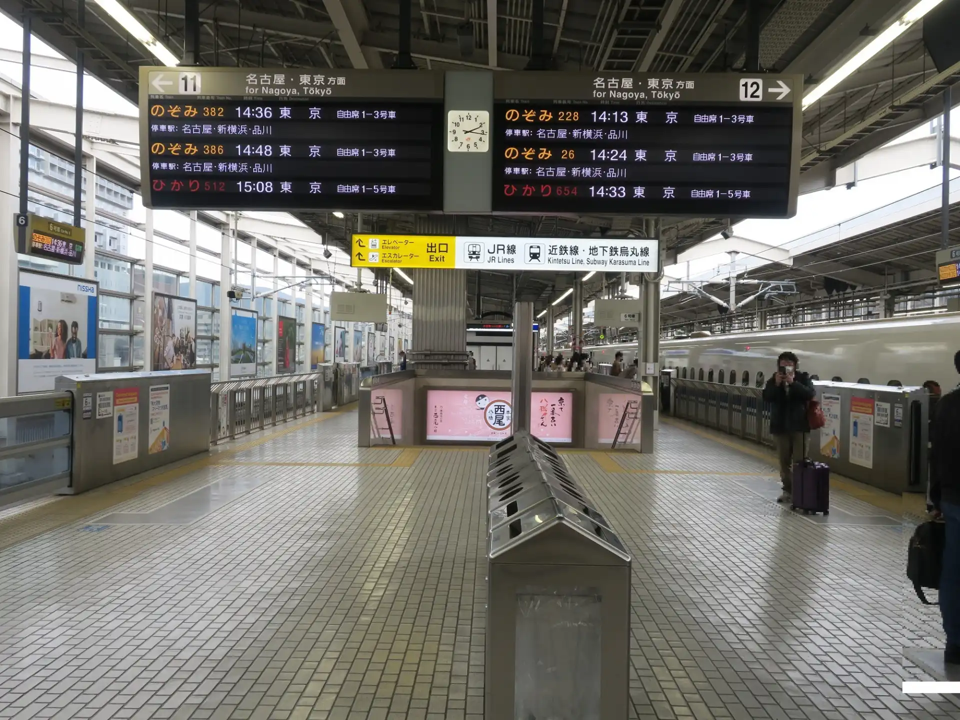 Eastbound Shinkansen platform at Kyoto Station with signs for tracks 11 and 12 and the departure information