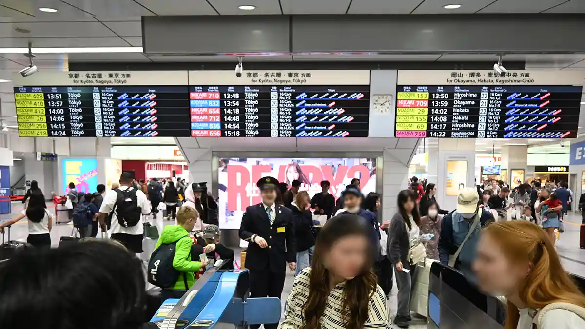 Shinkansen departure board at Shin-Osaka Station above Central Gate showing train times and platforms