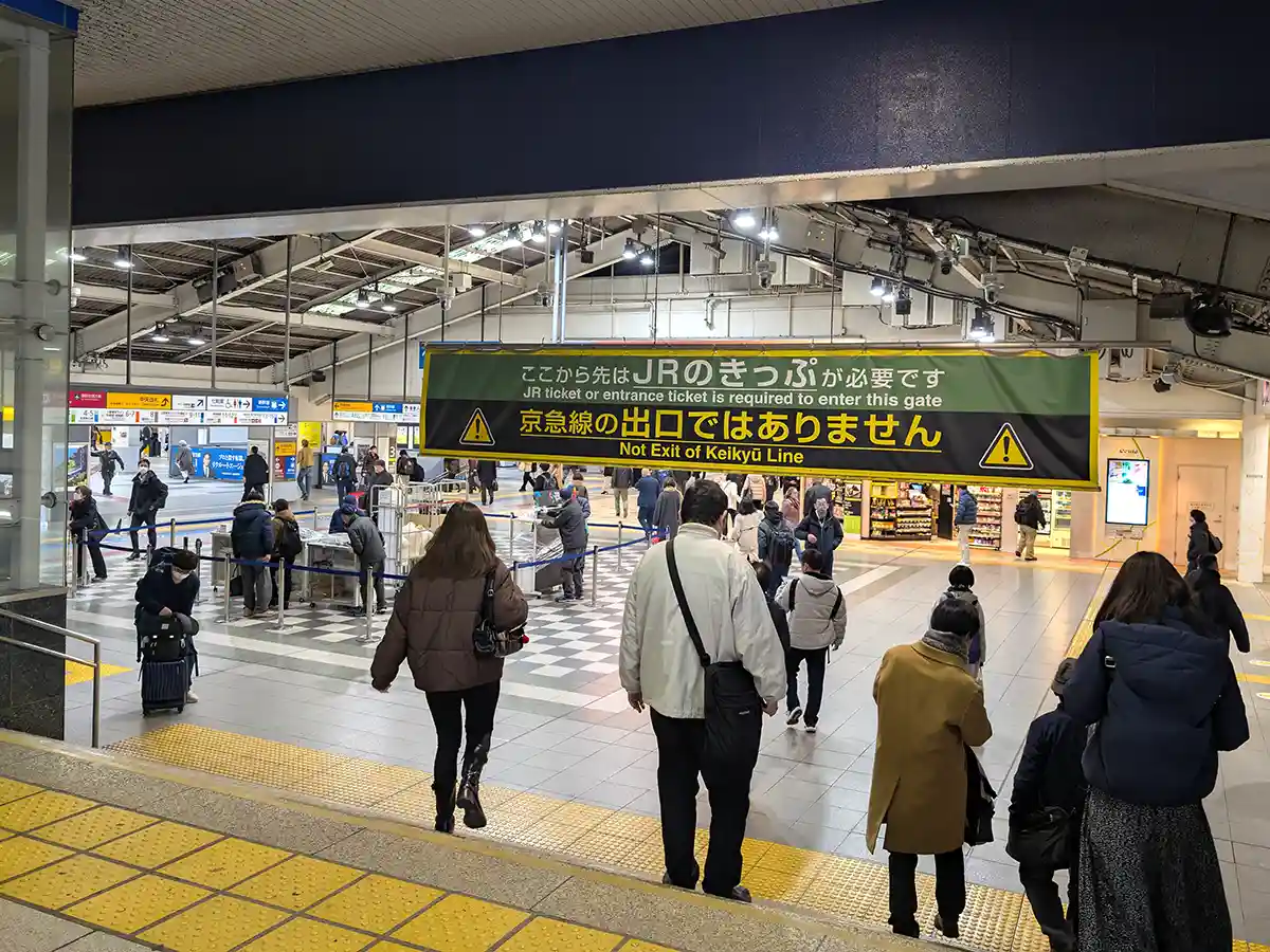 JR concourse at Shinagawa Station after Keikyu Line gates with passengers walking toward transfer area