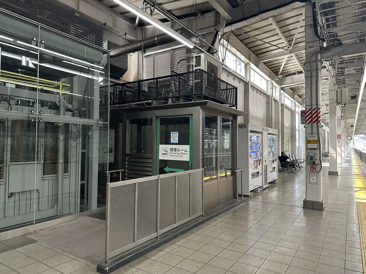 Smoking room on the Shinkansen platform at Hakata Station near vending machines and seating
