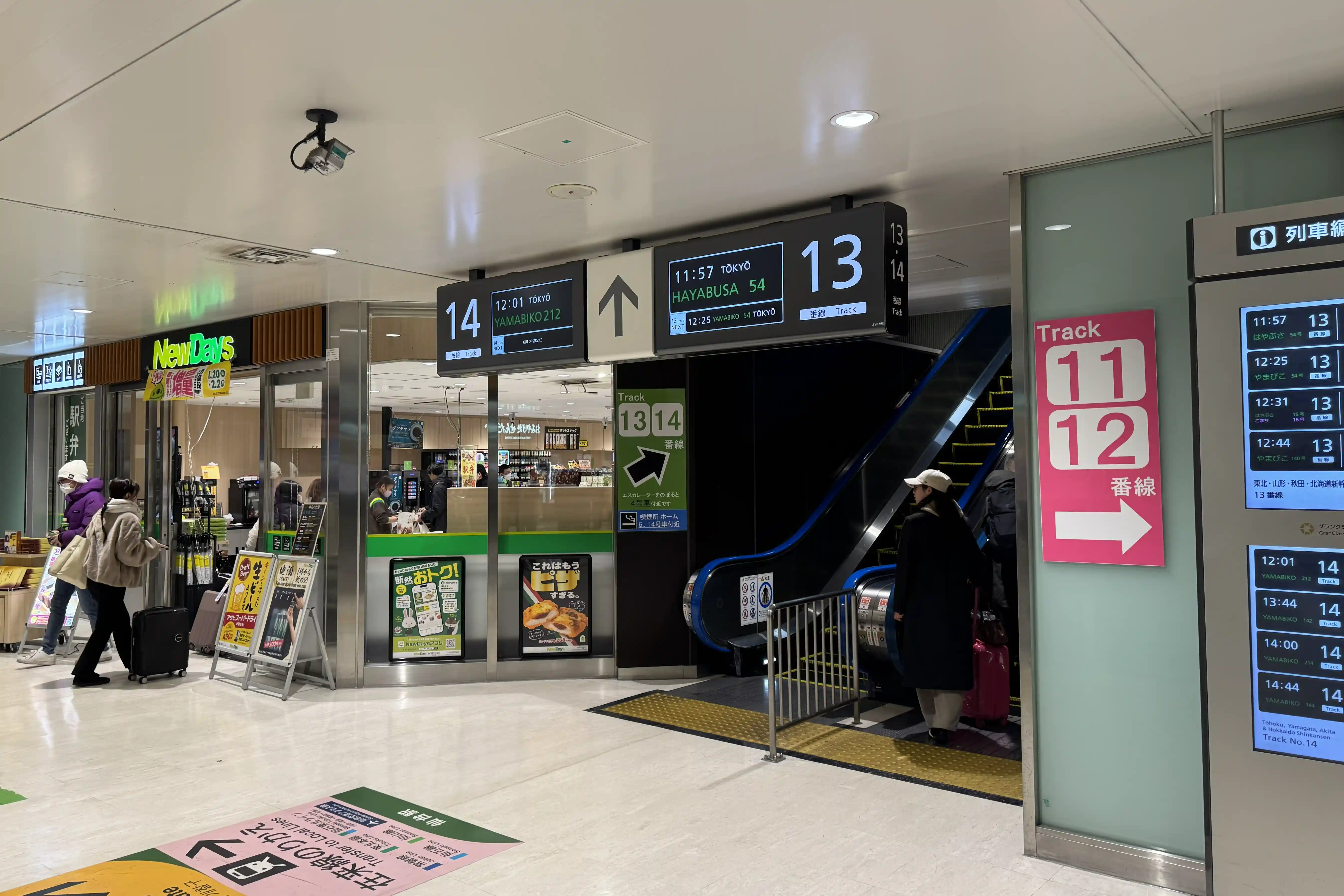 Escalator inside the Shinkansen gates at Sendai Station leading passengers toward platforms 13 and 14.