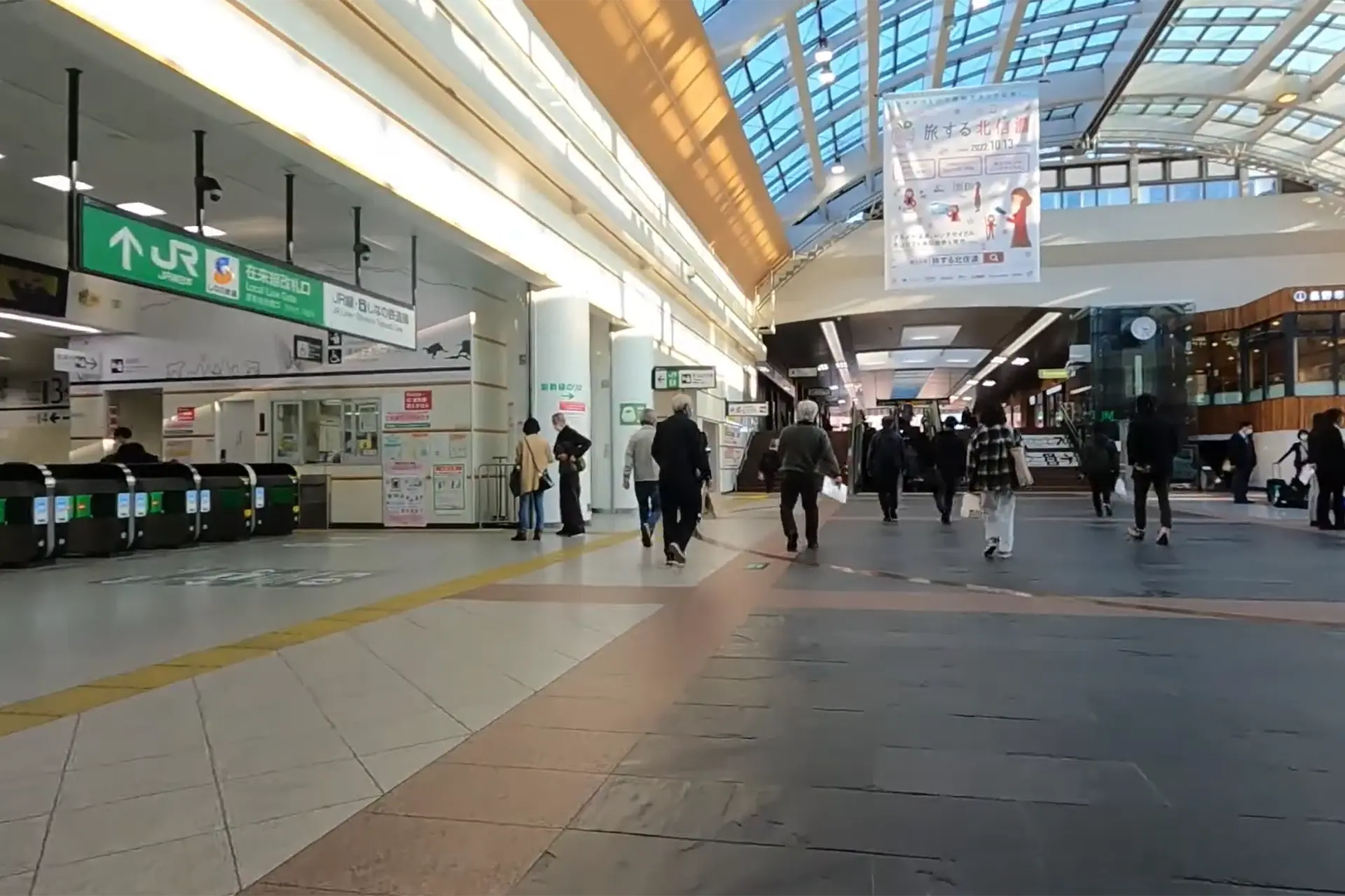 Main concourse inside Nagano Station with ticket gates and the spacious glass-roofed hall