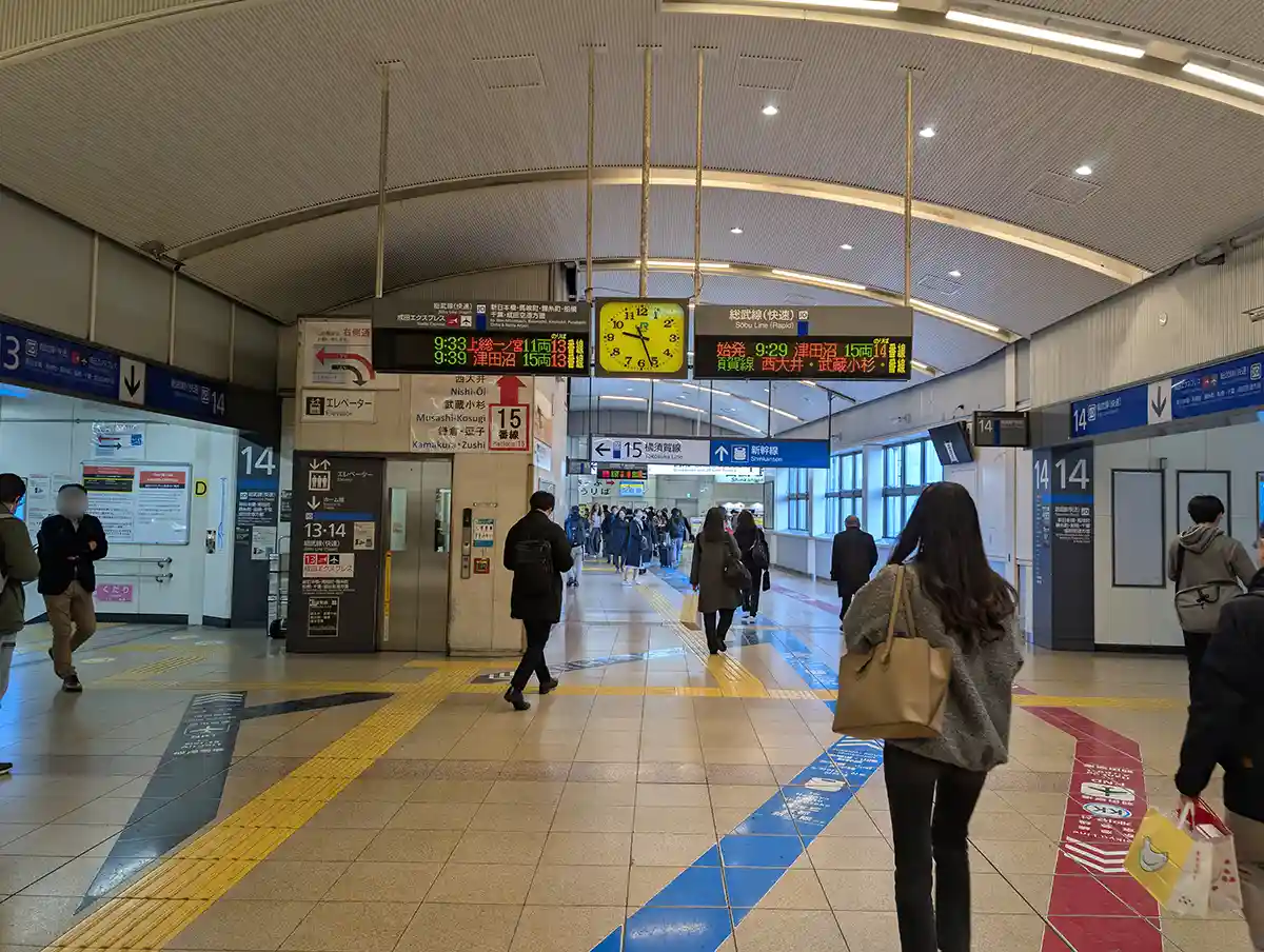 JR concourse at Shinagawa Station near Shinkansen area with overhead signs and passengers walking