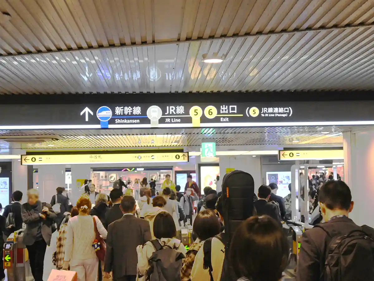 Osaka Metro Midosuji Line concourse with ticket gates and signs pointing to Shinkansen and JR lines