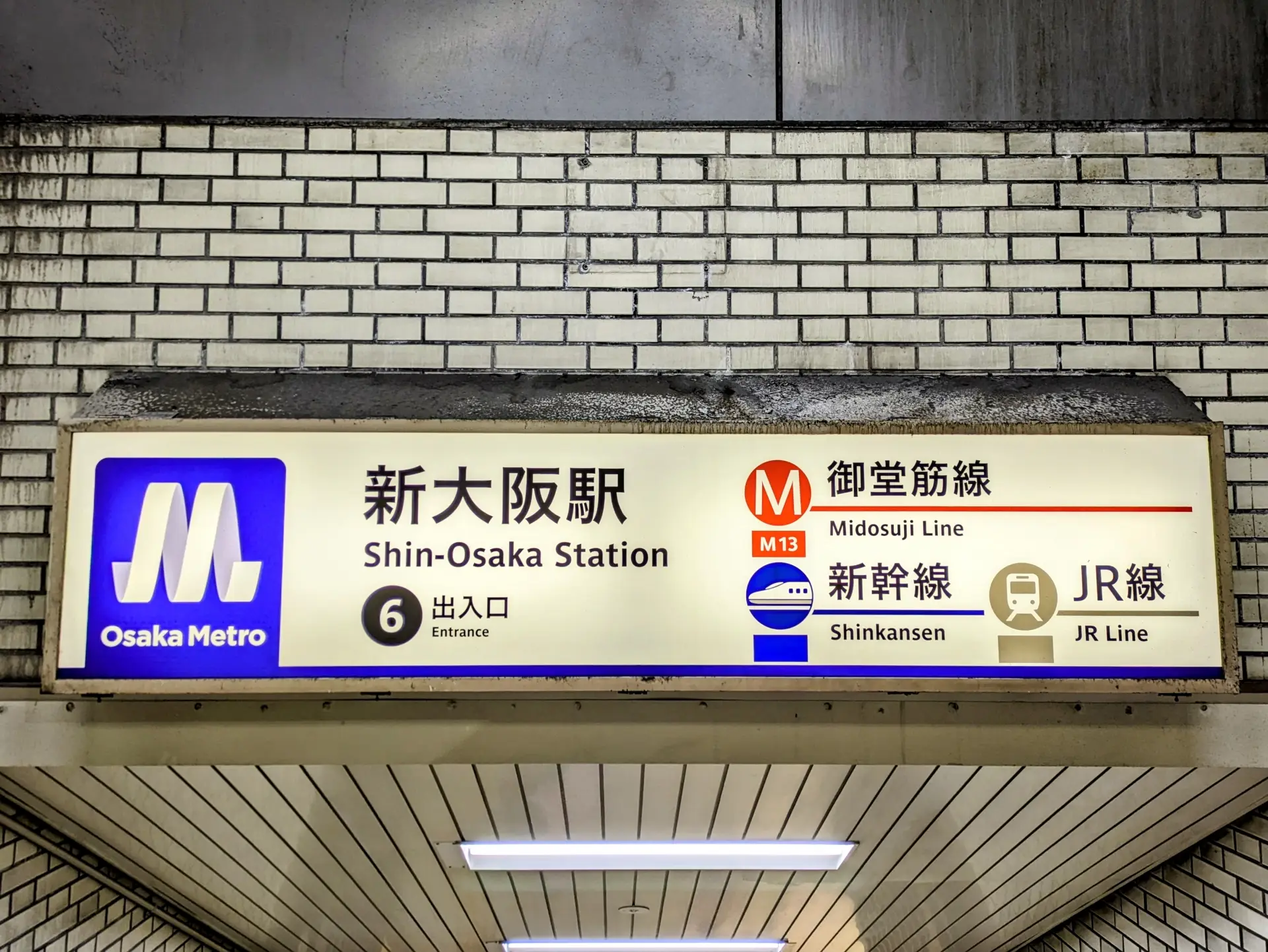 Sign at Shin-Osaka Station showing directions to Shinkansen, JR Line, and Osaka Metro Midosuji Line