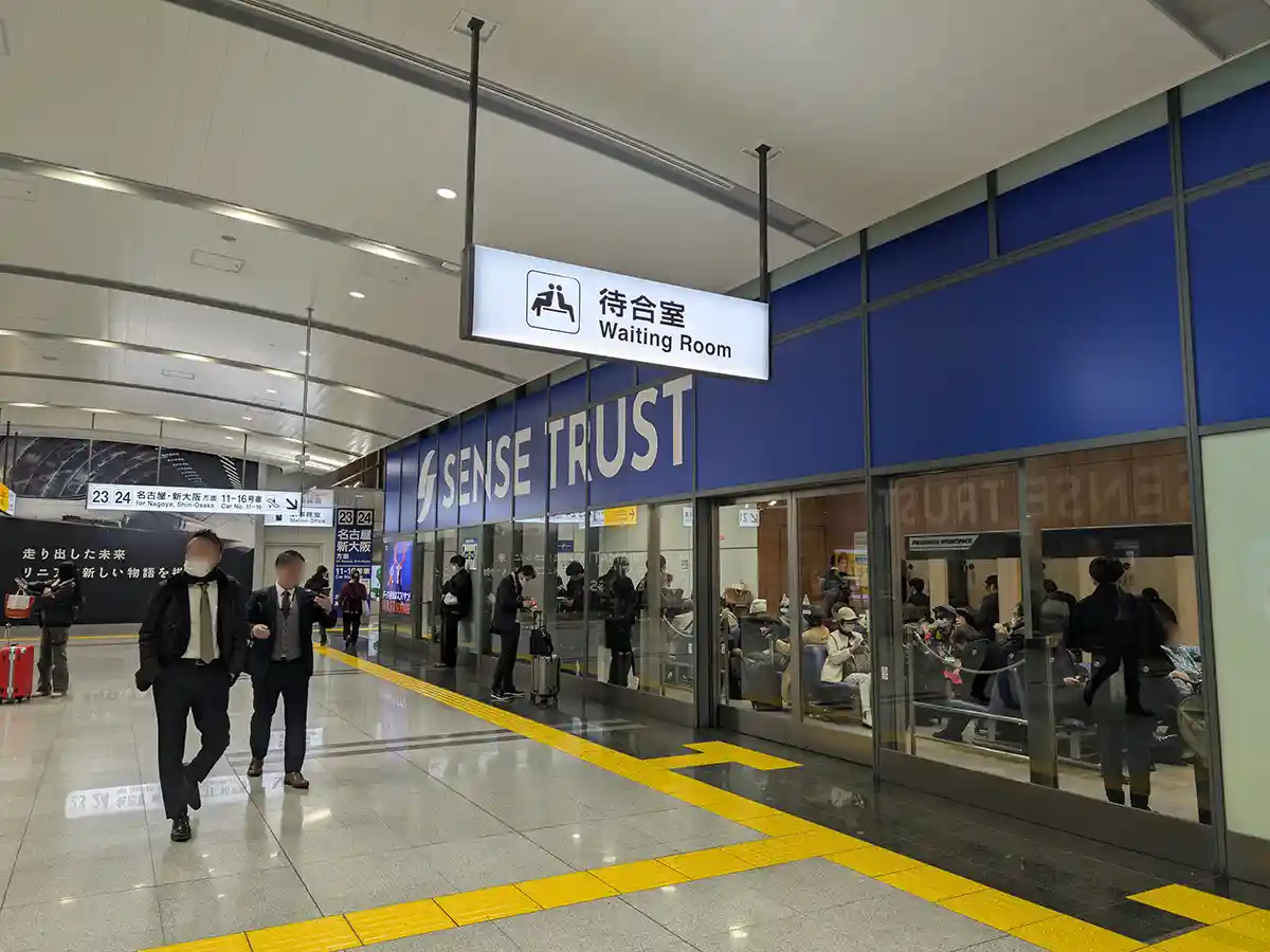 Shinkansen waiting room inside Shinagawa Station with passengers seated before boarding Shinkansen