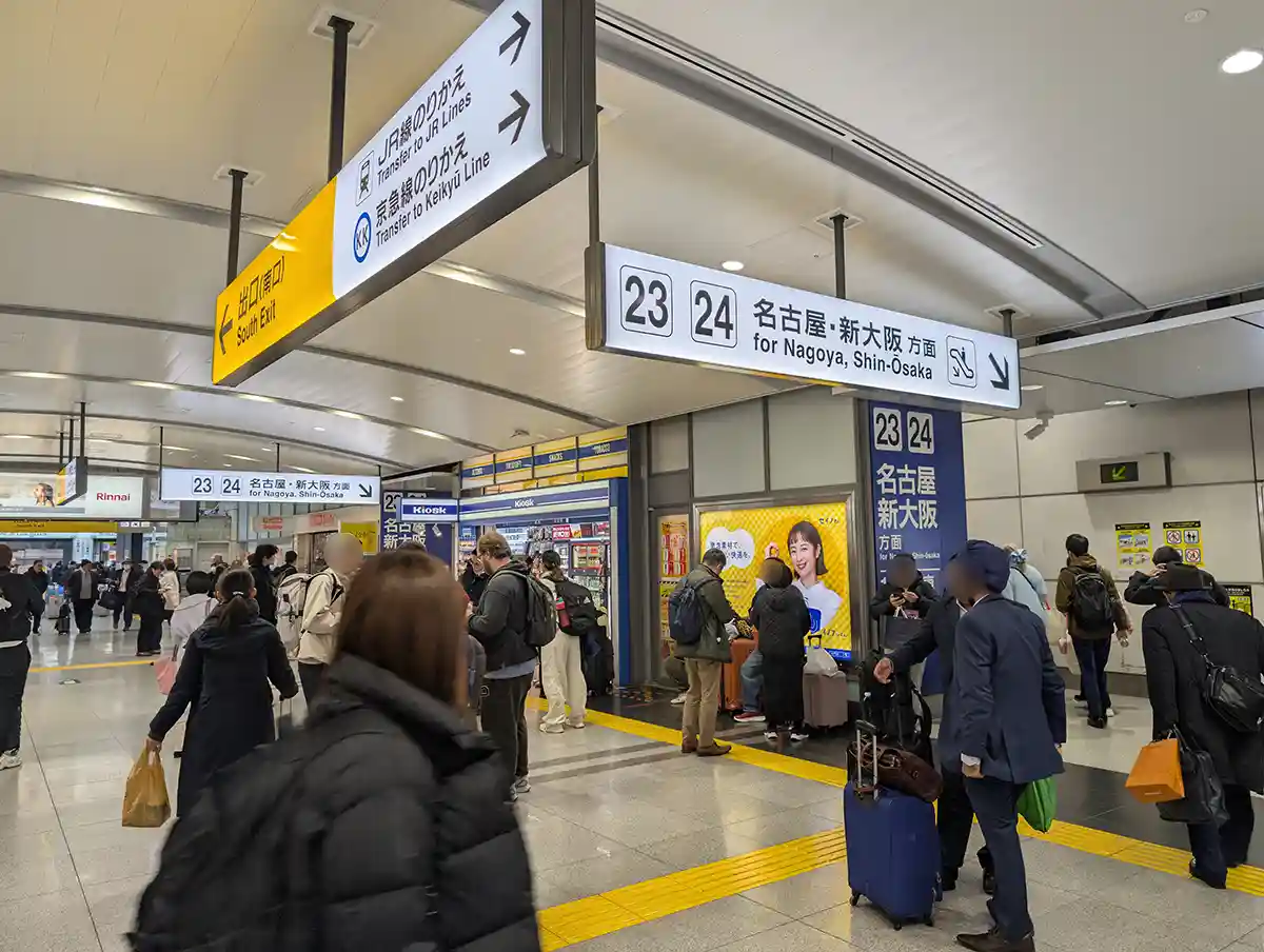Overhead and wall signs inside Shinagawa Shinkansen area showing directions to platforms 23 and 24