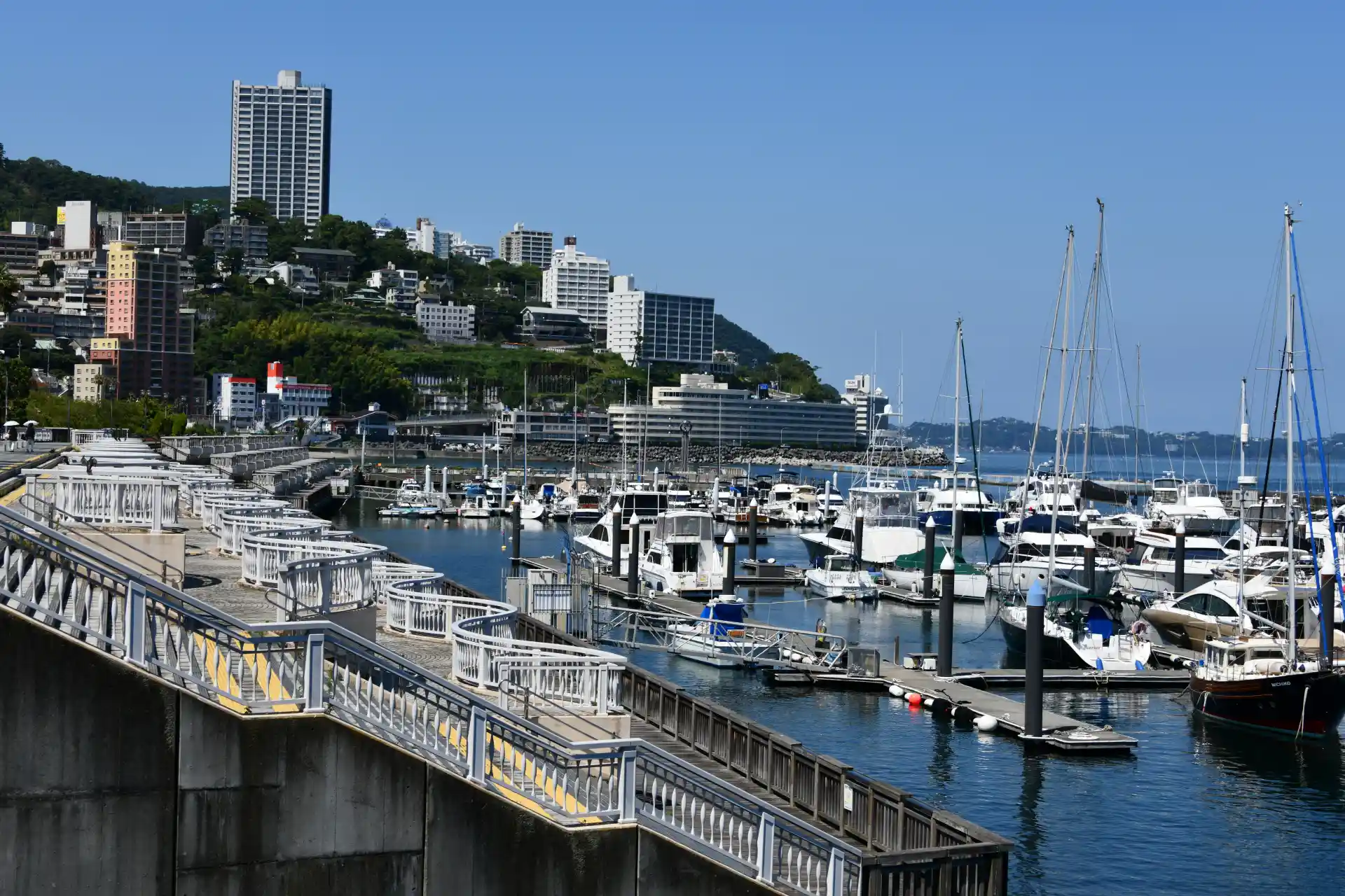 Atami coastal cityscape with boats and resort buildings along the bay