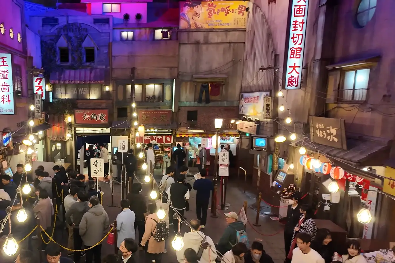 Interior scene of Shin‑Yokohama Ramen Museum, showing retro-styled ramen shops and visitors in line under hanging lights