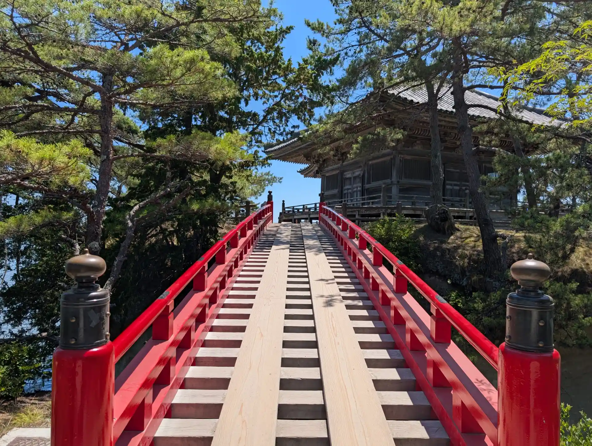 Red wooden bridge leading to Godaido Temple in Matsushima, a historic Buddhist hall near Sendai on the coast