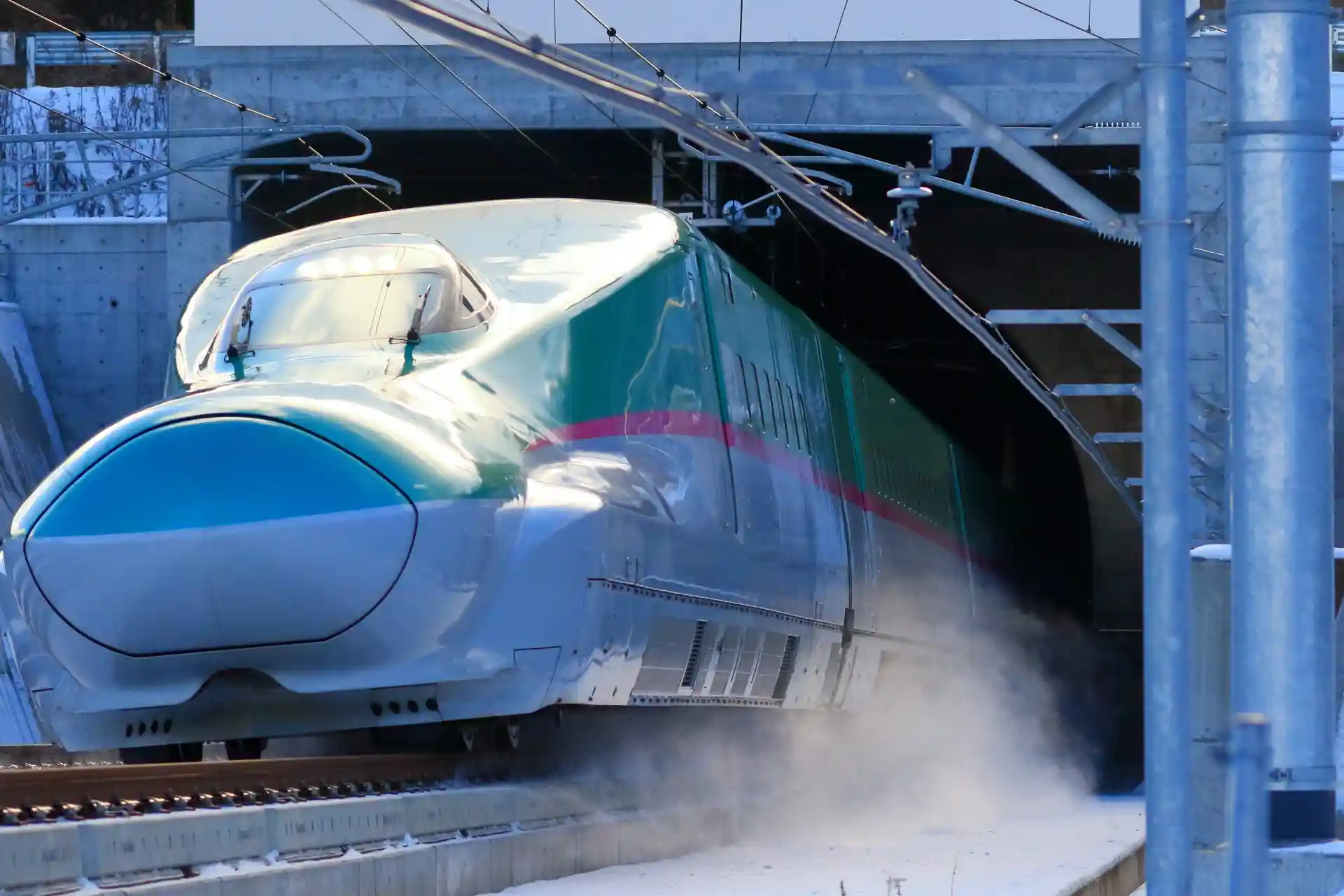 Hokkaido Shinkansen operating in snowy conditions, equipped with snowplows and track systems that support stable winter train operations