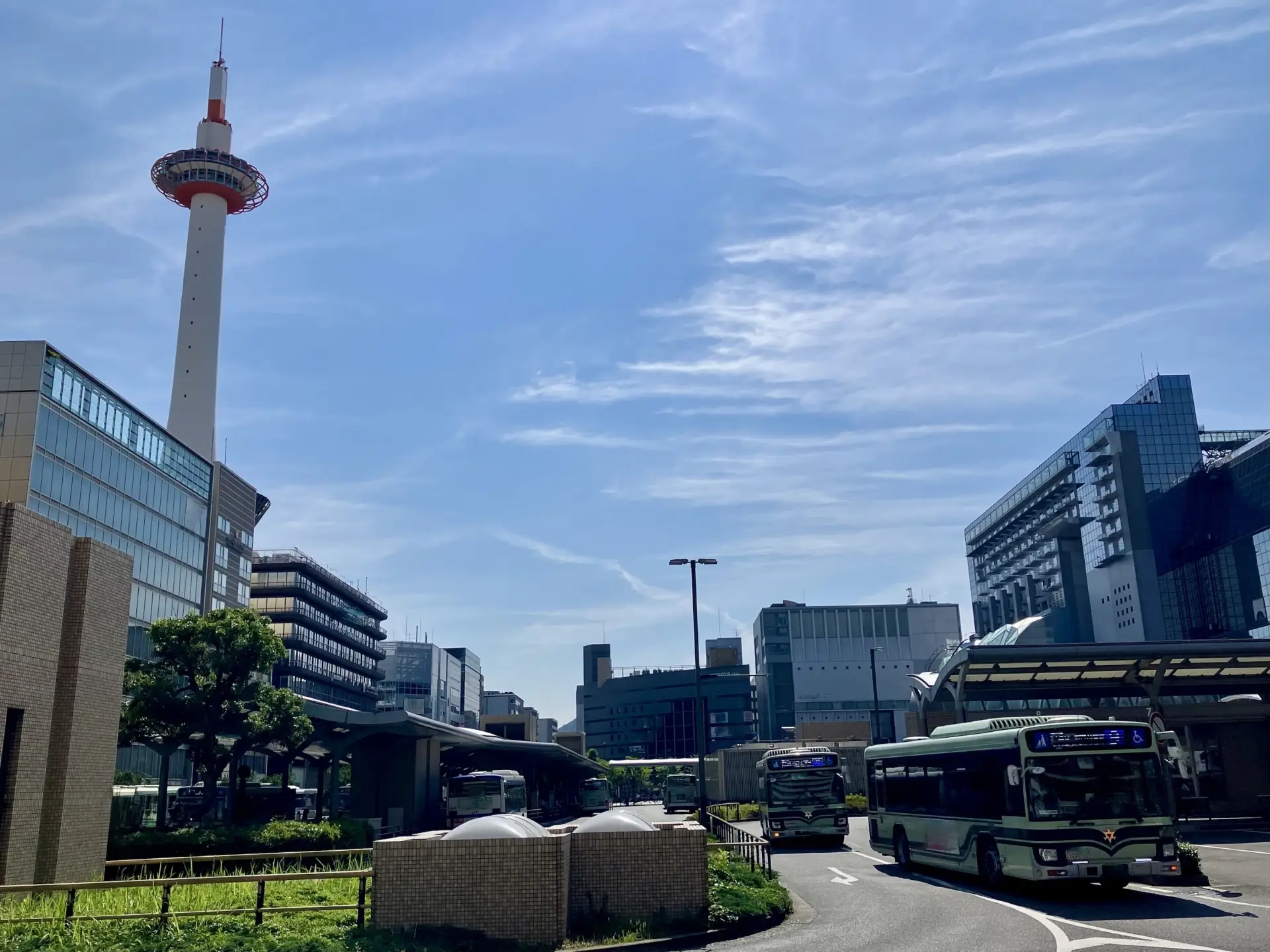 Kyoto Station bus terminal with city buses and Kyoto Tower in the background
