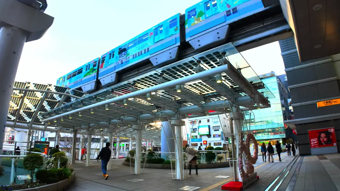 Kitakyushu Monorail passing through Kokura Station with people walking below