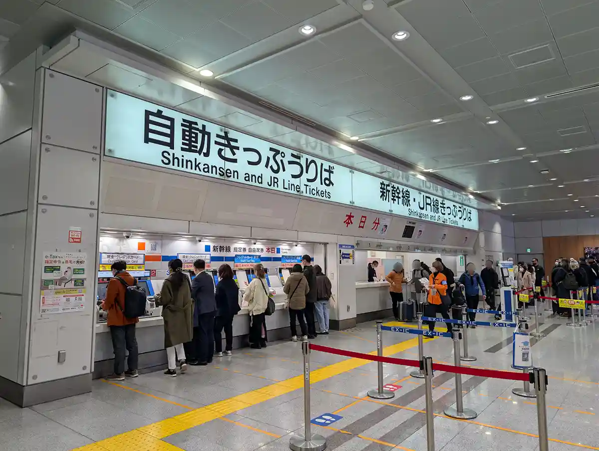 Shinkansen ticket machines and counters at the south transfer area of Shinagawa Station with people lining up