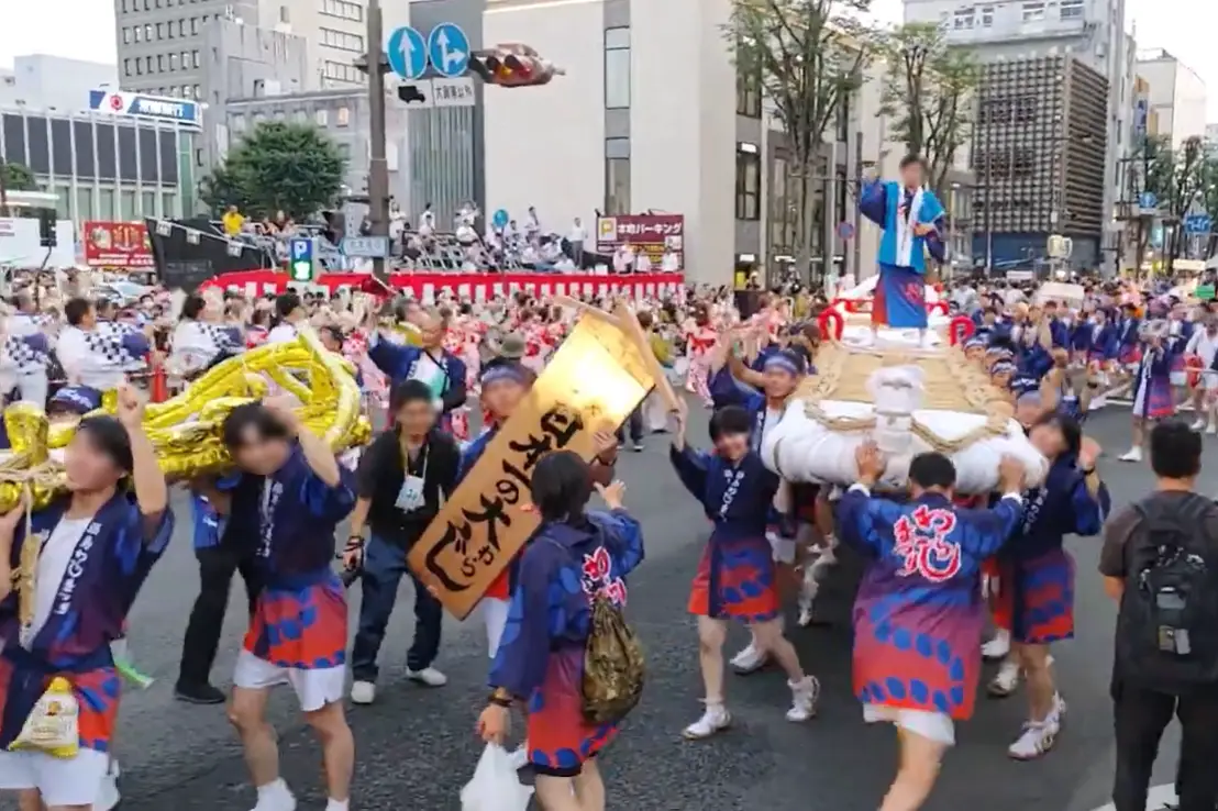 Participants parading with giant straw sandal float at Fukushima Waraji Festival in Japan