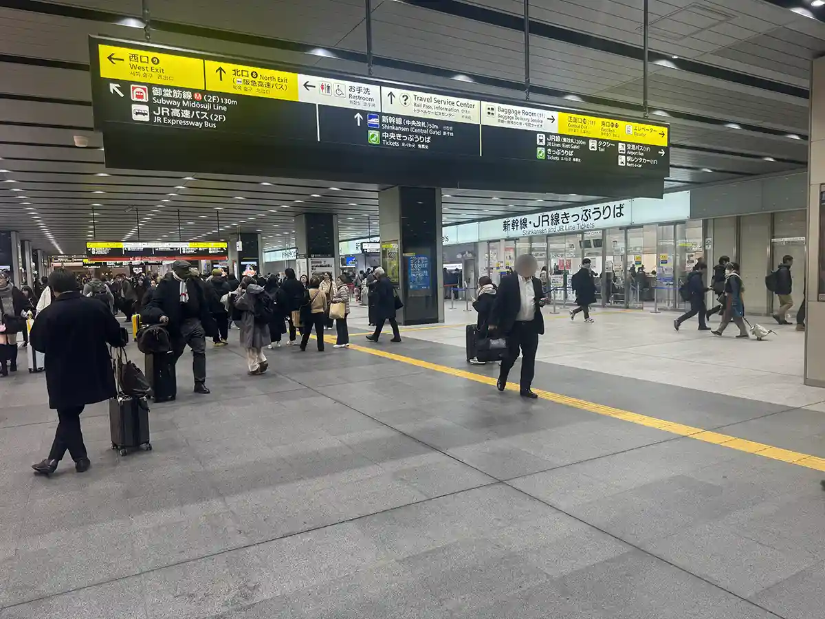 Shin-Osaka Station main concourse displaying directional signs for Shinkansen platforms and station facilities for travelers